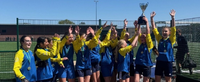 The Eckington School U12 Girls Football Team cheering and lifting their Derbyshire County Cup trophy